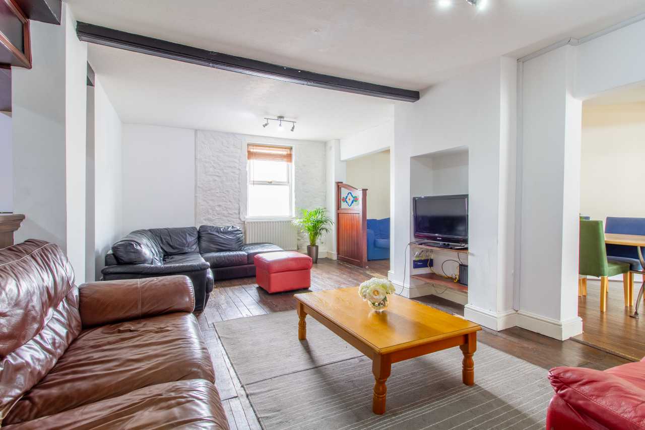 Bright living room with sofas, a coffee table, television and an adjoining dining area.