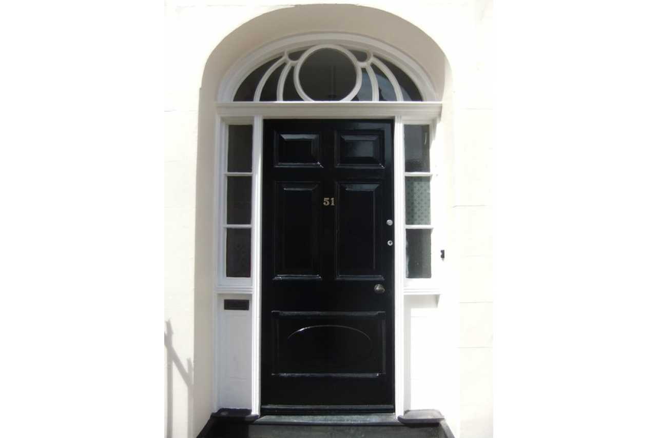 Front entrance with a black door, white surround, sidelights and an arched fanlight.