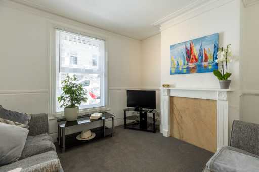 Living room with sofas, a television, a window, a fireplace and wall art.